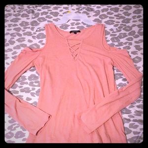 A blush pink shoulder cutout shirt with neck cross